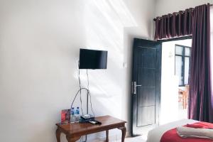 1 dormitorio con 1 cama y 1 mesa con lámpara en Cahaya Adrian Near Komodo Airport en Labuan Bajo