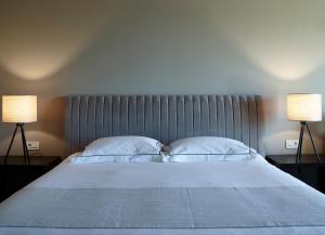 a bedroom with a large bed with two lamps at Pelagos Suites Hotel & Spa in Kos