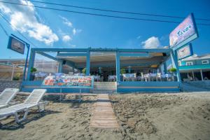 a restaurant on the beach with two chairs and a bench at Aktypis Beachfront Studios in Laganas