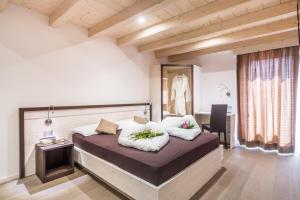 una camera da letto con un grande letto con due cuscini sopra di Hotel La Sorgente a Tesero