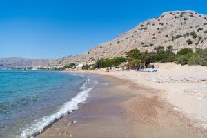 a sandy beach with a mountain in the background at Tesoro Del Mare in Pefki Rhodes