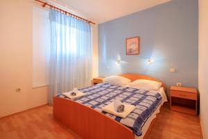 a bedroom with a bed with two towels on it at Apartments Lola in Novalja