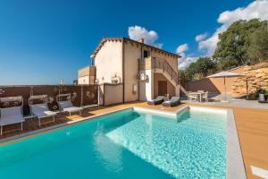 a villa with a swimming pool and a house at Villa Sa Rocca Junior & Suite in Chia