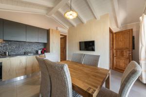 a dining room with a wooden table and chairs at Villa Sa Rocca Junior & Suite in Chia