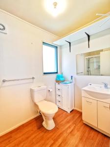 a bathroom with a toilet and a sink at Atarau Grove Studio in Paraparaumu