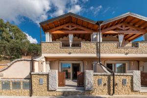 an image of a house with a wooden roof at Villa Sa Rocca Junior & Suite in Chia