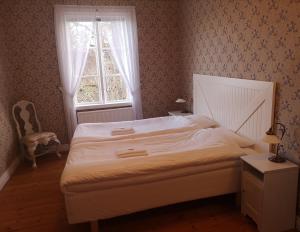 a bedroom with a white bed with a window at Gustafsbergs Badhotell & Vandrarhem in Uddevalla