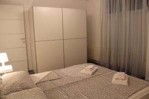 ein Schlafzimmer mit einem Bett mit zwei Handtüchern darauf in der Unterkunft Nicely decorated apartment Silver in Fažana