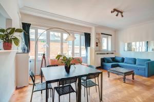 a living room with a table and a blue couch at The Grand Apartment. Center of Antwerp in Antwerp