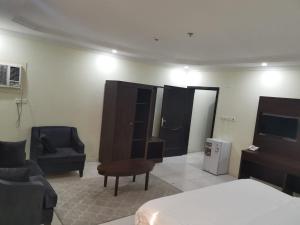 a room with a bedroom with a bed and a tv at شقق دخيل بن نقا بن شنيشيل الرحيلي للشقق المخدومة in Medina +19 photos