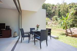 una sala da pranzo con tavolo e sedie e un giardino di 2 Bedroom Duplex Pool Villa A SDV005-By Samui Dream Villas a Mae Nam