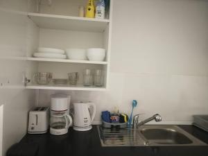 a kitchen counter with a sink and some appliances at La Cala Finestrat Apartment in Cala de Finestrat