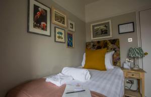 a bedroom with a bed with white and yellow pillows at Dunstan House in Burnham on Sea