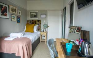 a bedroom with a bed and a desk with a desk at Dunstan House in Burnham on Sea