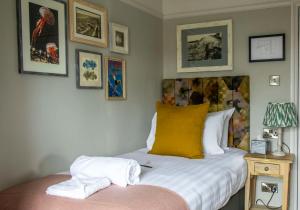 a bedroom with a bed with two towels on it at Dunstan House in Burnham on Sea