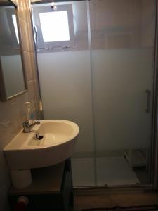 a bathroom with a sink and a glass shower at La Cala Finestrat Apartment in Cala de Finestrat