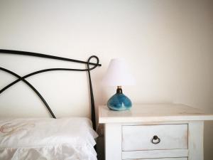 a bedroom with a bed with a lamp on a night stand at Casa Cortes in Desulo
