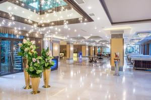 a lobby with vases of flowers on the floor at Ambassadori Tbilisi Hotel in Tbilisi City