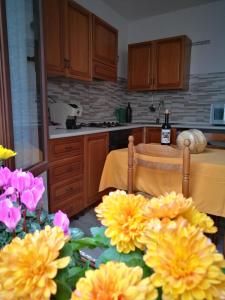 een keuken met een tafel met gele en roze bloemen bij Casa Cortes in Desulo
