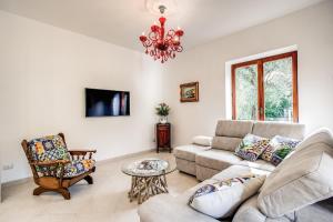 een woonkamer met een bank, stoelen en een kroonluchter bij MEDITERRANEAN HOUSE in Sorrento