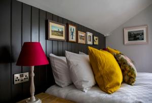 a bedroom with a bed with a red lamp and pillows at Dunstan House in Burnham on Sea