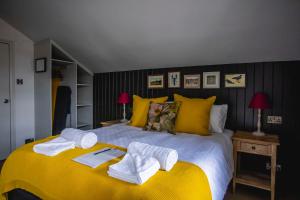 a bedroom with a yellow bed with towels on it at Dunstan House in Burnham on Sea