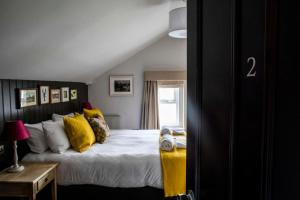 a bedroom with a bed with yellow pillows at Dunstan House in Burnham on Sea