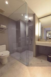a bathroom with a shower and a toilet and a sink at FOX Hotel Pekanbaru in Pekanbaru