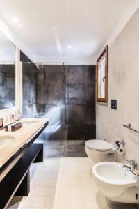 a bathroom with a sink and a toilet and a shower at Hotel Aquadulci in Chia