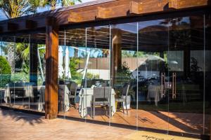a dining area with glass walls and a table and chairs at Hotel Aquadulci in Chia