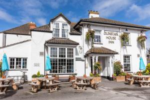 a pub with picnic tables in front of it at Dunstan House in Burnham on Sea