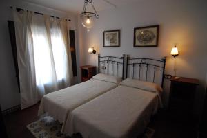 a bedroom with a bed with a white bedspread and a window at Apartamentos San Juan 16 in Archidona