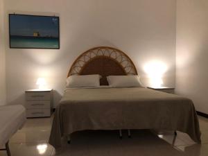 een slaapkamer met een groot bed met 2 lampen bij Piacentini - Locazione turistica - San Pietro in Bevagna in San Pietro in Bevagna