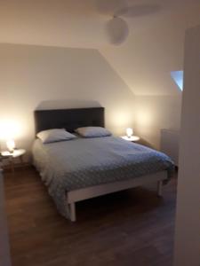 una camera da letto con un letto con due lampade sopra di Manoir de La Converserie a Saint-Étienne-au-Mont