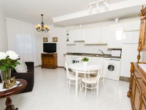 a kitchen and living room with a table and chairs at Alojamientos Garden Ribadeo in Ribadeo