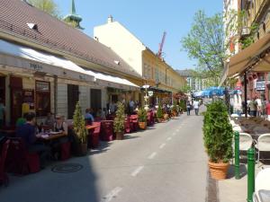 a street with restaurants and people sitting at tables at E13 - Elegant Apartment in Budapest