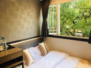 Bett in einem Zimmer mit Fenster in der Unterkunft Vve Vve Hotel in Hongkong