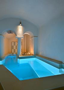 una gran piscina azul en una habitación en THE A COLLECTION by K&K, en Oia