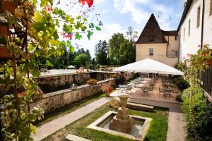 
a patio area with a table, chairs and umbrellas at Château de Gilly in Vougeot
