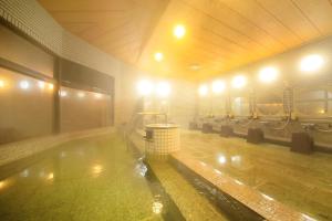 a swimming pool in a building with lights on at Oarai Park Hotel in Oarai
