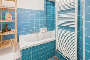 a blue tiled bathroom with a sink and a shower at The Grand Apartment. Center of Antwerp in Antwerp