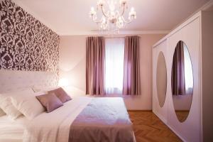 a bedroom with a large bed and a chandelier at Apartments Villa Paradise in Kaštela