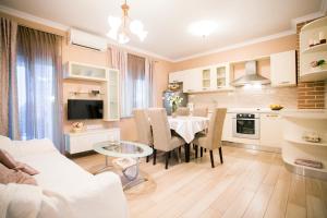 a kitchen and living room with a table and a couch at Apartments Villa Paradise in Kaštela