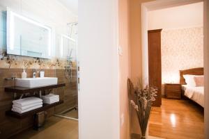 a bathroom with a sink and a bedroom with a bed at Apartments Villa Paradise in Kaštela +37 photos