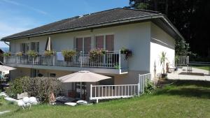 una casa con un balcón con flores. en Ferienwohungen Wassertheurer, en Sankt Kanzian
