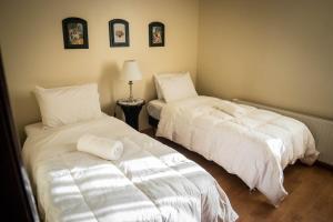 dos camas sentadas una al lado de la otra en una habitación en Departamentos Los Ganaderos en Punta Arenas