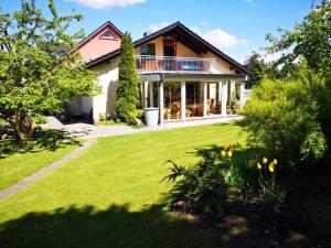 ein Haus mit grünem Rasen davor in der Unterkunft Ferienwohnungen Maintal in Karlstadt