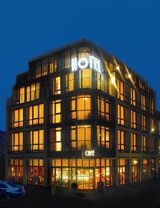 a large building with a sign on it at night at KONCEPT HOTEL Benedikt vormals H2O in Siegburg