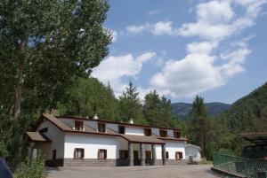 a white building with a lot of windows and trees at El Chate Tiendas in Sarvisé