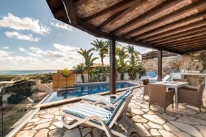 a villa with a swimming pool and a patio at Villa Thea in Peyia